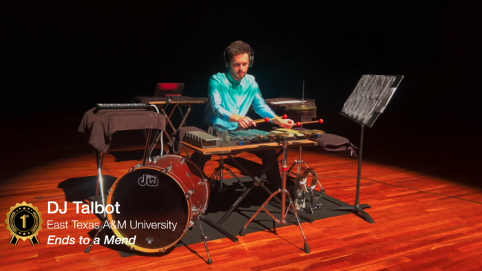 A person playing multiple percussion instruments on a stage.